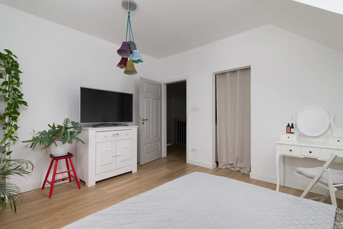 Słoneczna sypialnia z oknami połaciowymi – strefa relaksu w domu na sprzedaż.